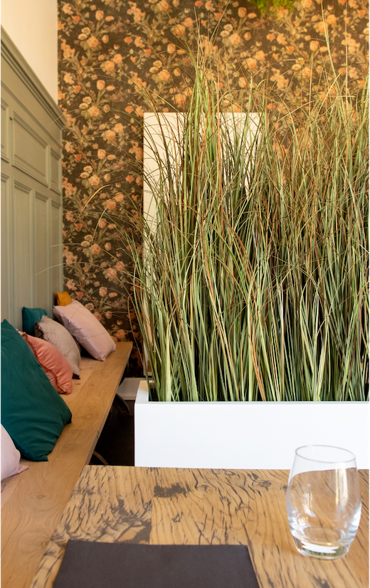 Séparateur en graminées entre deux tables d'un restaurant
